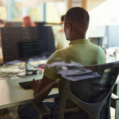 AI-Evaluation-System A QA professional analyzing system performance data on a monitor to evaluate AI quality.