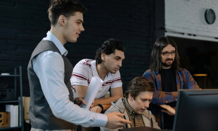 A four-member engineering team works around a desk