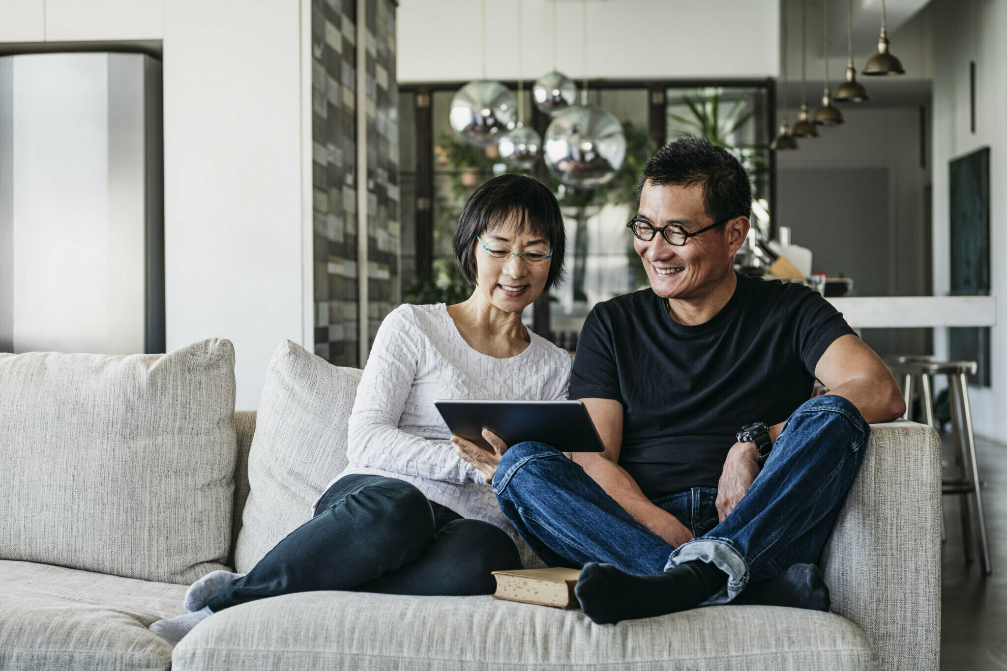 A couple watches a streaming program on a tablet.