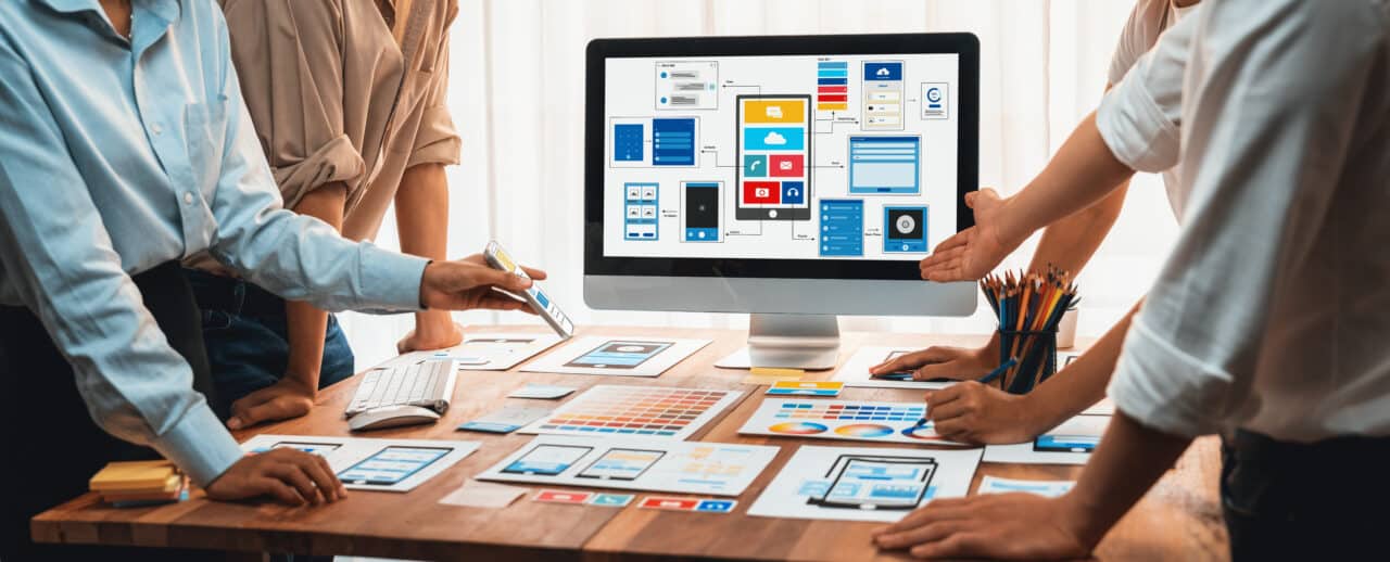 People gathered around a computer screen evaluating a UX design.