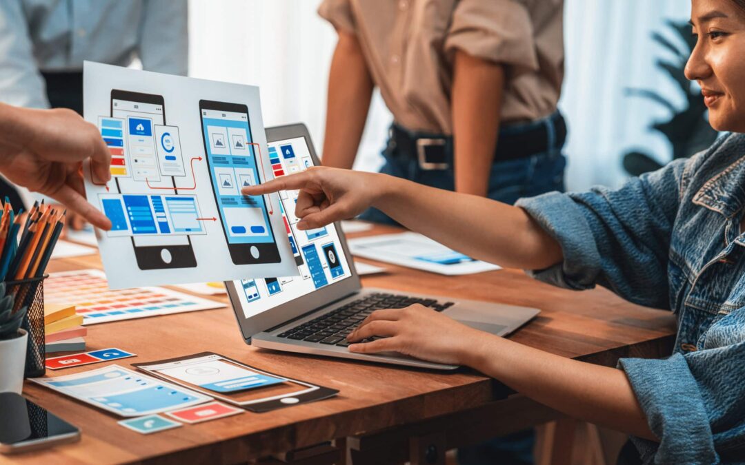 Panorama shot of front-end developer team brainstorming UI and UX designs for mobile app on paper wireframe interface. User interface development team planning for user-friendly UI design.