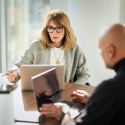 Two professionals collaborating on a laptop during an automation consultation.