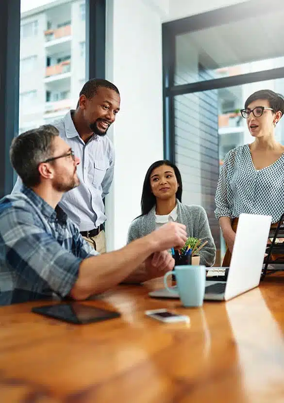 A team of people collaborating over a presentation on a laptop.