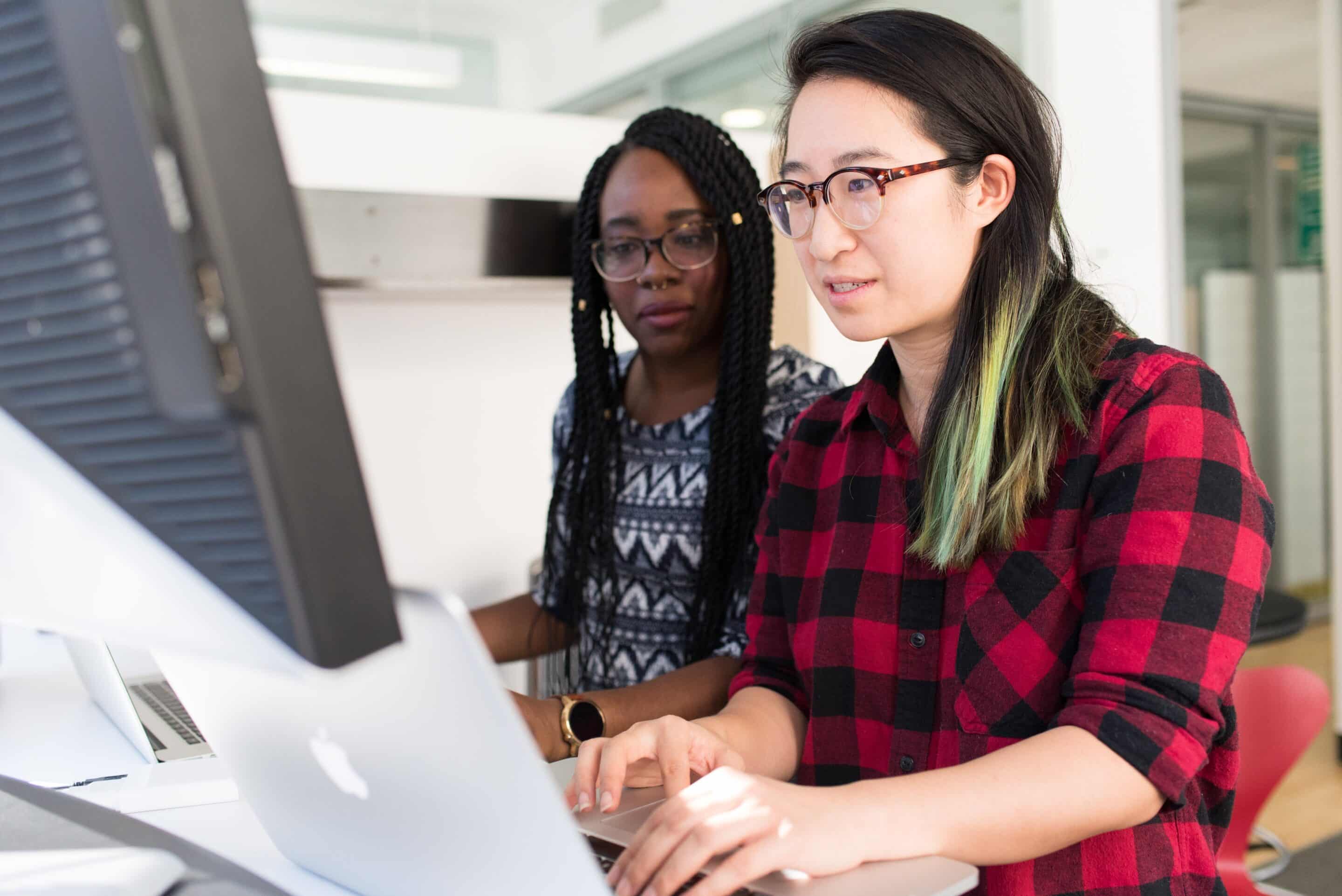 pexels-christina-morillo-1181472-scaled-1 Women looking at a large monitor and working on a laptop